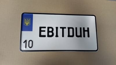 Номерной знак на квадратній пластині